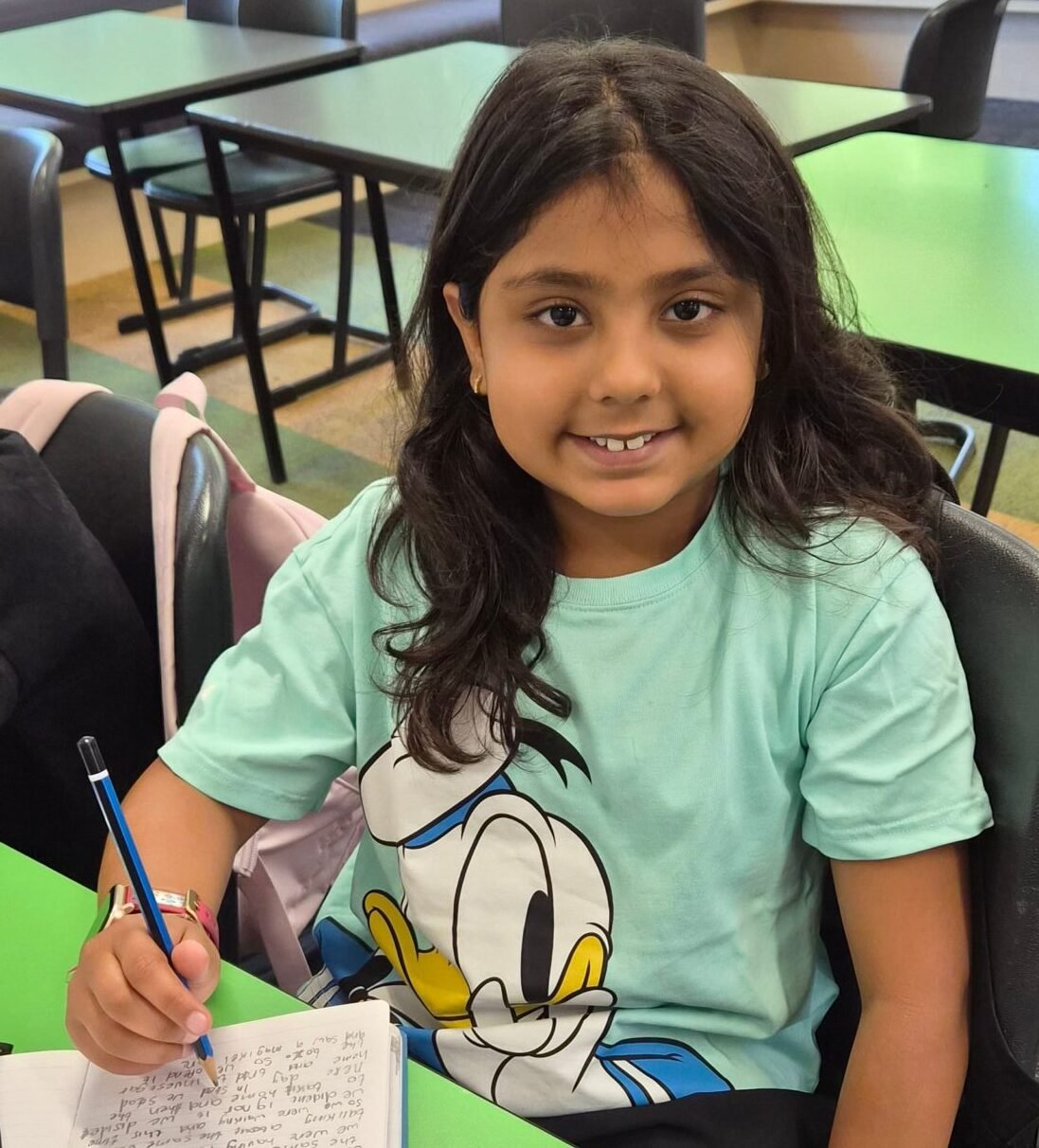 Student writing in a notebook during a NRICH Learning session