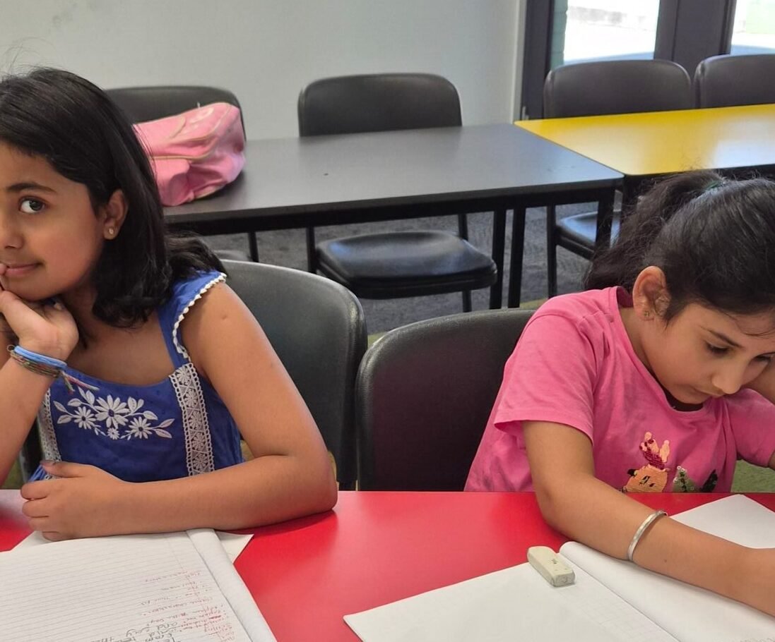 Young students writing in their notebooks at NRICH Learning